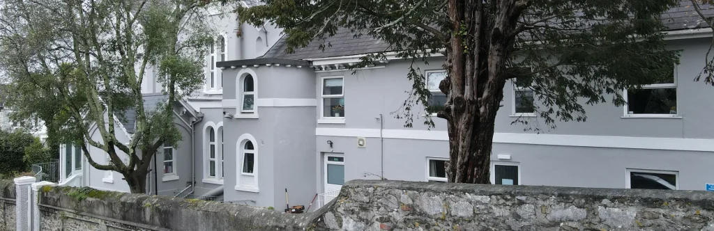 Chatsworth Residential Home seen from the road, behind a stone garden wall