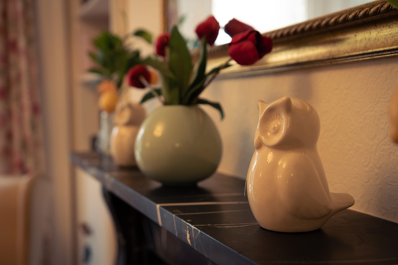 Flowers and ornaments on the mantelpiece in a lounge at The Elms