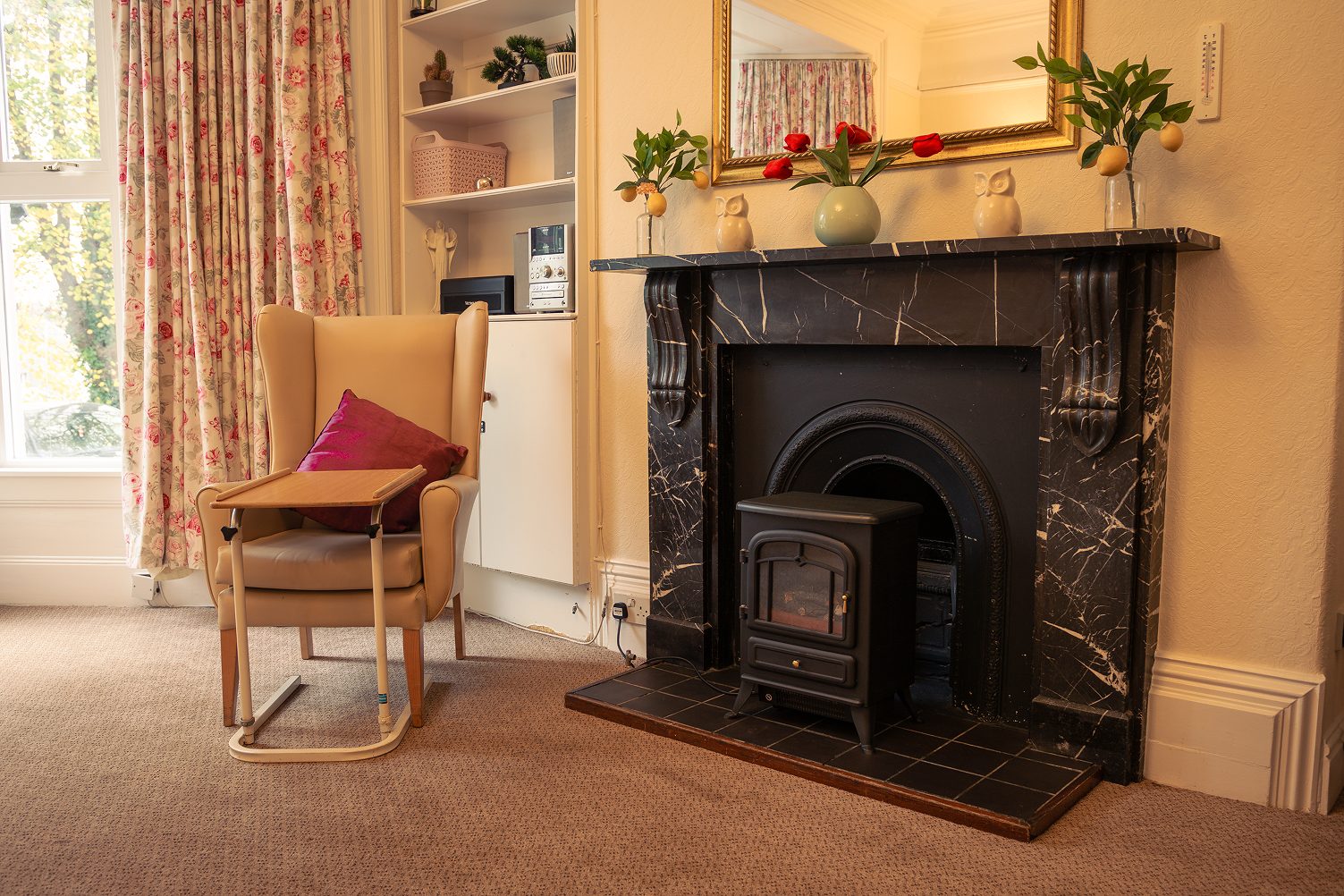 An armchair beside the marble fireplace in a lounge at The Elms